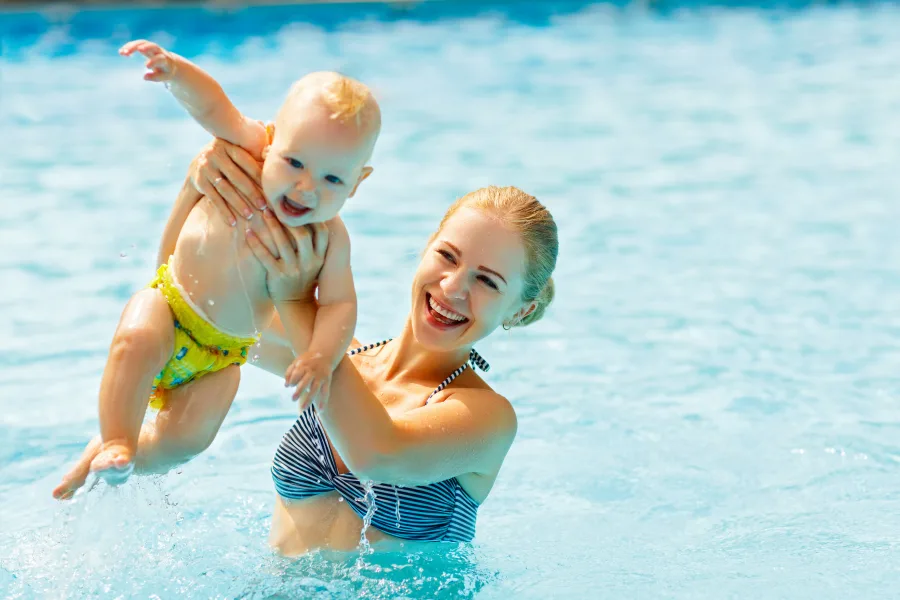 Mutter und Baby lachen im warmen Wasser